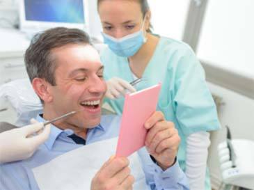 man with dental assistant looking at smile